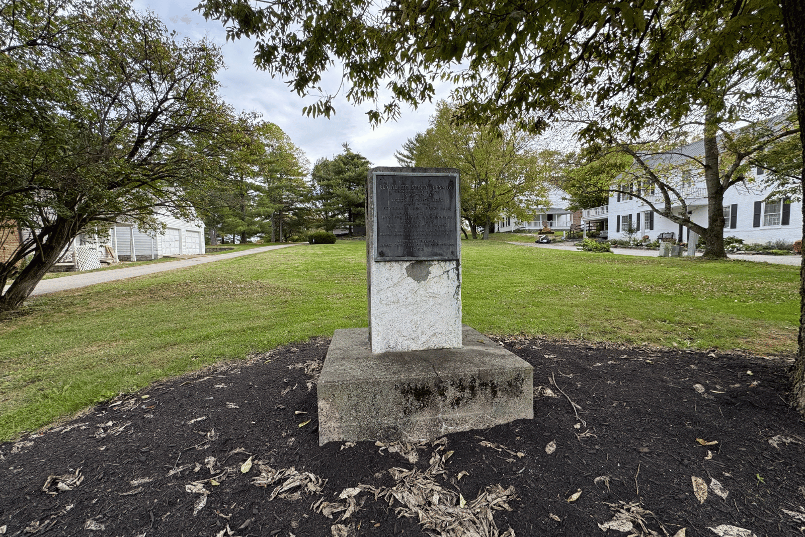 Albert Sidney Johnston Birthplace historical marker in Washington, Kentucky, surrounded by trees and historic white buildings.
